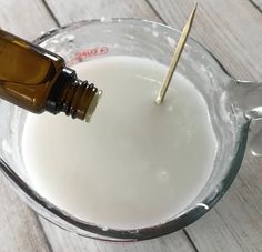 a glass bowl filled with white liquid and a toothpick sticking out of it