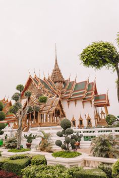 an ornate building with many trees and bushes around it