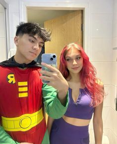 a man taking a selfie with a woman dressed as the incredible spider - man