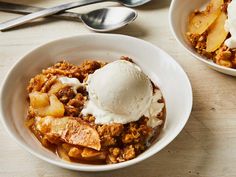 two bowls filled with food and ice cream on top of a wooden table next to spoons