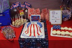 an american flag cake and cupcakes on a table