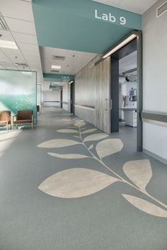 an empty hospital hallway with chairs and tables