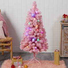 a pink christmas tree with lights and ornaments