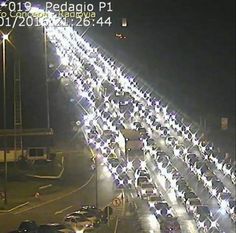 a long line of cars driving down a highway at night