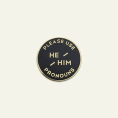 a black and gold pin with the words please use she they pronouns