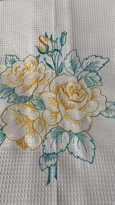 a white table cloth with yellow and blue flowers on it