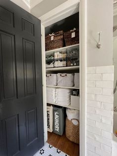 an open pantry door with baskets and other items in the closet next to each other