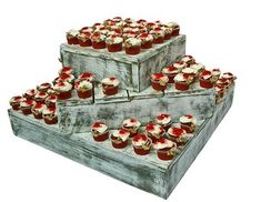 three wooden boxes filled with cupcakes sitting on top of each other in front of a white background