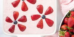 strawberries and yogurt in a white dish next to pink towel, bowl of strawberries