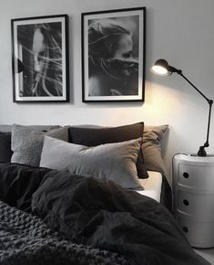 a bedroom with two pictures on the wall above the bed, and a lamp next to it