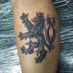 a black and white tattoo on the leg of a man with a lion in it