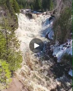 an aerial view of a waterfall in the woods