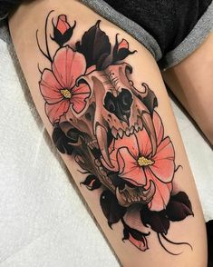 a woman's thigh with a skull and flowers on it