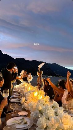 a group of people sitting at a table with plates and glasses in front of them