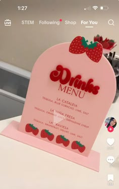 a pink sign with strawberries on it that says drink menu