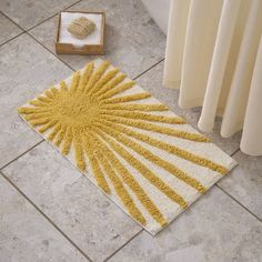 a yellow and white rug sitting on the floor next to a radiator in a bathroom