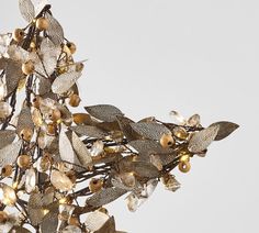 a chandelier with gold leaves and lights hanging from it's centerpiece