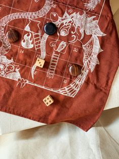 a red bag with white designs and wooden dices laying on the ground next to it