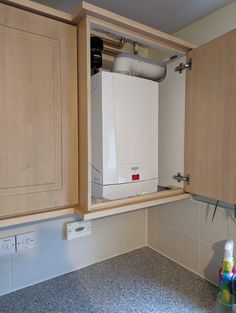 a white dishwasher sitting inside of a kitchen next to wooden cabinets and counter tops