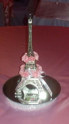 the eiffel tower is decorated with pink flowers and pearls on a black plate