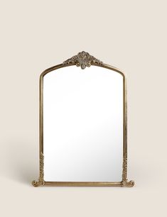 an ornate gold framed mirror against a white background