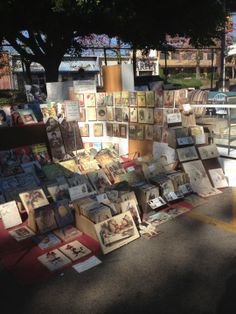 an outdoor market with pictures and cards on display