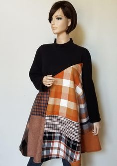 a mannequin is wearing a dress made out of plaid fabric and black sweater