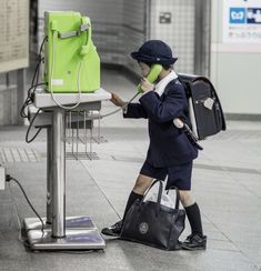 a person with a bag and cell phone on the ground next to a luggage cart