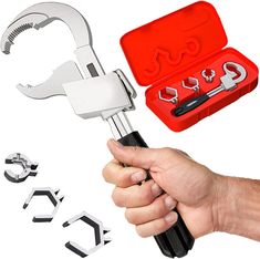 a hand holding a wrench with several tools in the case next to each other