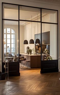 an open living room and dining area with large glass doors that lead to the kitchen