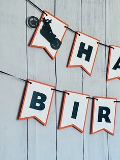 an orange and white banner that says happy birthday with a motorbike on it