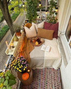 a bed sitting on top of a wooden floor next to a window covered in plants