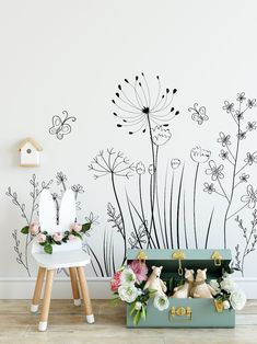 a suitcase with flowers on the floor next to a wall painted in black and white