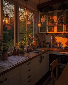 a kitchen filled with lots of counter top space next to a window covered in hanging lights