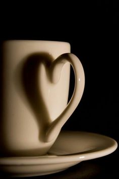 a white coffee cup with a heart shaped saucer