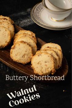 buttery shortbread walnut cookies on a wooden plate with a cup and saucer