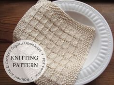 a knitted dishcloth sitting on top of a white plate next to a wooden table