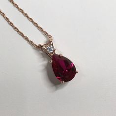 "Beautiful Ruby & White Sapphire Pendant Necklace set in 14k Rose Gold * Pear Cut Ruby measures 10x7mm * Single Brilliant Cut White Sapphire Accent measures 2.5mm * 2.7cts total Gemstone weight * 16\" or 18\" Chain Included * 14k Rose Gold Also Available in Sterling Silver or 14kt Yellow or White Gold - message me for details Hallmarked & Gift Ready! Matching Earrings & Ring Available This Ruby is laboratory grown. It is identical to natural in every way, including Chemistry, Composition and Har Pear-shaped Rose Gold Jewelry With Brilliant Cut, Pear-shaped Brilliant Cut Rose Gold Jewelry, Rose Gold Teardrop Ruby Jewelry, Rose Gold Jewelry With Prong Setting Drop Shape, Rose Gold Pear-shaped Gemstone Necklaces, Rose Gold Pear-shaped Gemstone Necklace, Rose Gold Pear-shaped Ruby Jewelry, White Sapphire Necklace, Alexandrite Necklace