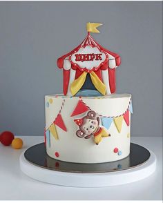 a circus themed birthday cake with a monkey on the front and circus tent in the back