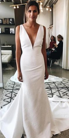 a woman in a white wedding dress posing for the camera