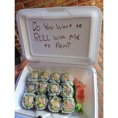 a white box filled with sushi next to a sign that says do you want to roll with me to pomp?