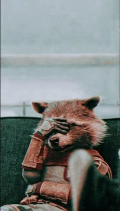 a raccoon is sitting on top of a man's back wearing a leather jacket