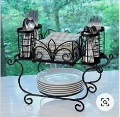 a table with plates, silverware and utensils in a holder on it