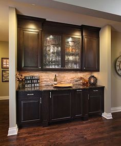 a kitchen with dark wood cabinets and a clock on the wall above it is shown