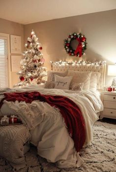 a bedroom decorated for christmas with white and red decor