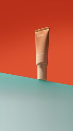 a tube of sunscreen sitting on top of a blue and orange table next to an orange wall