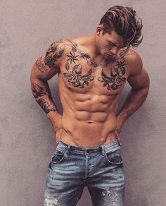 a shirtless man leaning against a wall with his hands on his hips