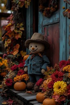 a teddy bear wearing a cowboy hat sitting in front of fall decorations