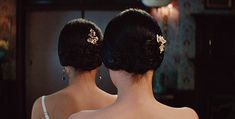 the back of two women's heads with hair combs in their buns