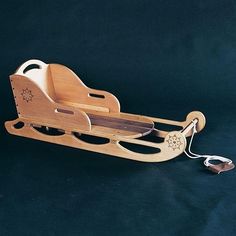 a wooden toy sled with two wheels and an electric cord attached to the sleigh